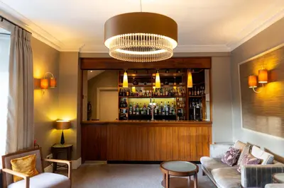 a living room with a bar with a couch at Rothay Garden by Harbour Hotels in Grasmere