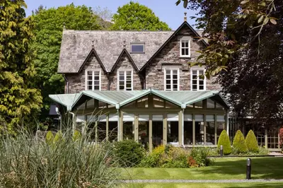 an old house with a conservatory in the garden at Rothay Garden by Harbour Hotels in Grasmere