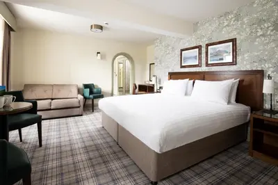 a hotel room with a large bed and a couch at The Swan at Grasmere- The Inn Collection Group in Grasmere