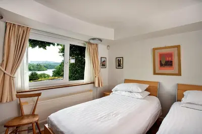 two beds in a room with a window at Finest Retreats - Unerigg in Grasmere