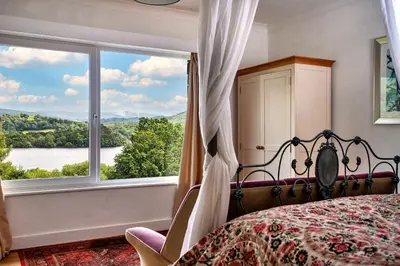 a bedroom with a bed and a large window at Finest Retreats - Unerigg in Grasmere