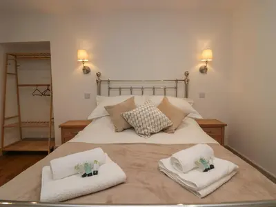 a bedroom with a bed with towels on it at Heather's Cottage in Carlisle