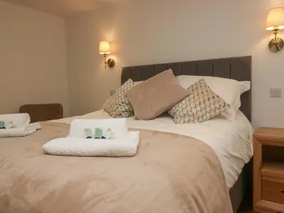 a bedroom with a bed with two towels on it at Heather's Cottage in Carlisle