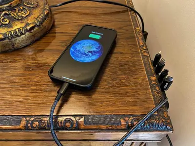 a cell phone hooked up to a charger on a table at Tre in Douglas