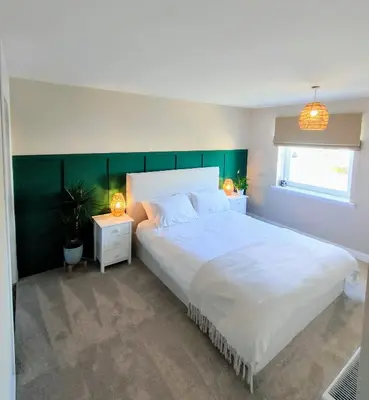 a bedroom with a large white bed and two night stands at Troon Beach and Golf House in Barassie