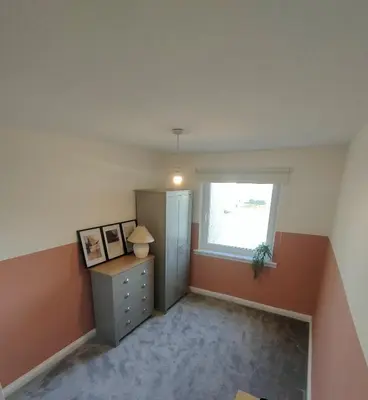an empty room with a dresser and a window at Troon Beach and Golf House in Barassie
