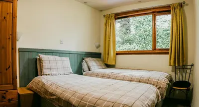a bedroom with two beds and a window at Heatheryhaugh Lodges in Moffat