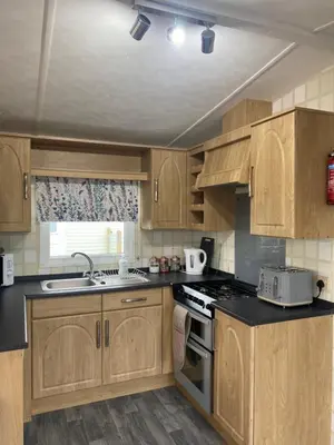 a kitchen with wooden cabinets and a stove top oven at 19 Forest Views in Plumbland