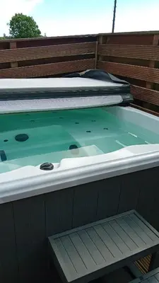 a hot tub on a boat with two beds at Baytree Lodge at three lochs holiday park, NEW ASK ABOUT OUR PACKAGES birthday ,anniversary,family,pamper packages available in Balminnoch