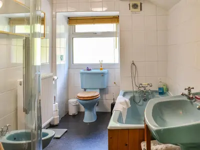 a bathroom with a tub and a toilet and a sink at Church House in Ulpha