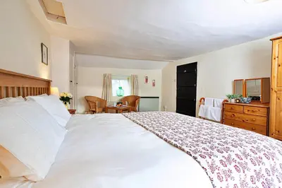 a bedroom with a large white bed and a desk at Finest Retreats - Town Head Cottage in Grasmere in Grasmere