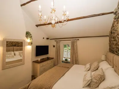 a bedroom with a bed and a chandelier at Style Cottage in Keswick