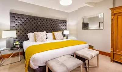 a bedroom with a large bed with a yellow blanket at Pippin Cottage in Keswick