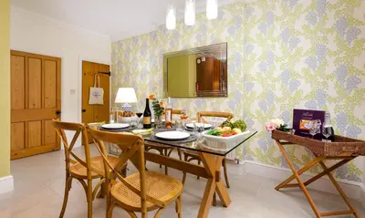 a dining room with a table with a bowl of fruit at Pippin Cottage in Keswick