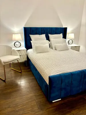 a bedroom with a blue bed and a chair at Golf View in Prestwick