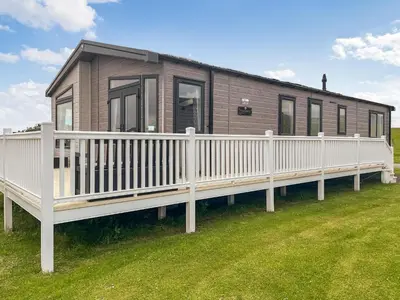 a house with a white rail and a porch at Uk47534 - Sea View 82 in Mainsriddle