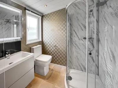 a bathroom with a shower and a toilet and a sink at Uk47534 - Sea View 82 in Mainsriddle