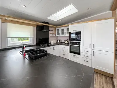 a kitchen with white cabinets and a stove top oven at Uk47534 - Sea View 82 in Mainsriddle
