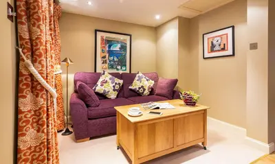 a living room with a purple couch and a table at Underscar - Latrigg in Keswick