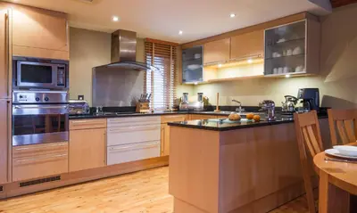 a large kitchen with stainless steel appliances and wooden cabinets at Underscar - Manesty in Keswick