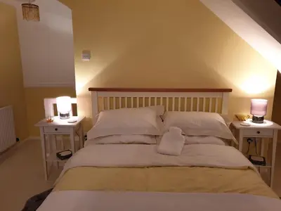 a bedroom with a bed with two night stands at The Old Cornstore a beautiful Suite overlooking the sea in Drummore