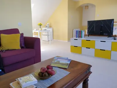 a living room with a table and a tv at The Old Cornstore a beautiful Suite overlooking the sea in Drummore