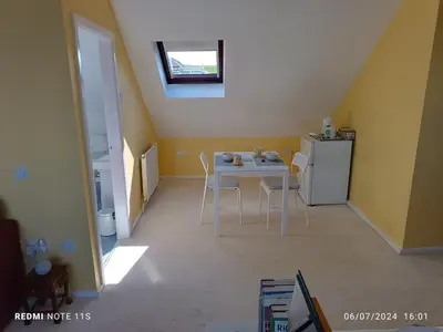 a small kitchen with a table and a refrigerator at The Old Cornstore a beautiful Suite overlooking the sea in Drummore