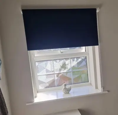 a window with a blue curtain and a vase on a window sill at The Old Bank at St Bees, Western Lakes in St Bees
