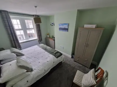 a bedroom with a bed and a cabinet and a window at The Old Bank at St Bees, Western Lakes in St Bees