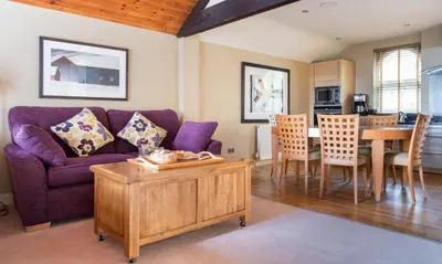 a living room with a purple couch and a table at Underscar - Beckstones in Keswick
