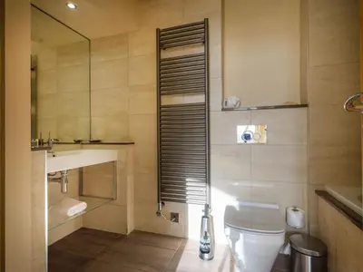 a bathroom with a toilet and a sink and a mirror at Underscar - Grange in Keswick