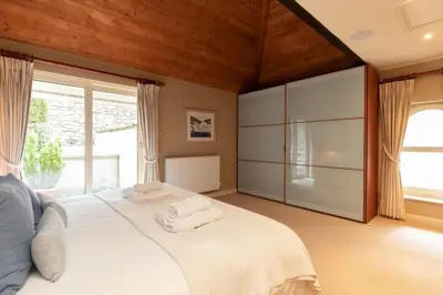 a bedroom with a large white bed with towels on it at Underscar - Skiddaw in Keswick