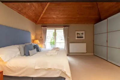 a bedroom with a large white bed and a window at Underscar - Skiddaw in Keswick