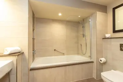 a bathroom with a bath tub and a toilet at Underscar - Skiddaw in Keswick