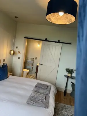 a bedroom with a white barn door and a bed at Firth View 2 - Country Escape with Sea Views of Arran! in Ayr