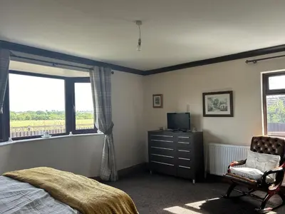 a bedroom with a bed and a tv and a chair at wonderful 4 bedroom cottage sleeps 8 in Carlisle