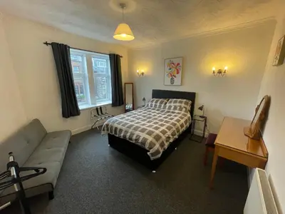 a bedroom with a bed and a couch at DG1 1ST Floor Flat in Dumfries