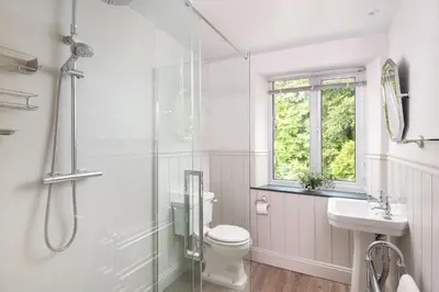 a bathroom with a toilet and a sink and a shower at Lydia's River Cottage in Keswick