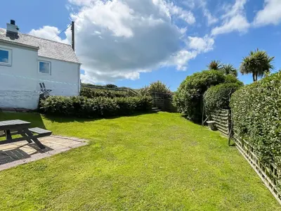 a picnic table in a yard next to a house at Rose Cottage in Port Logan