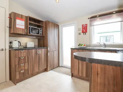 a kitchen with wooden cabinets and a counter top at 31 Forest Views in Cockermouth
