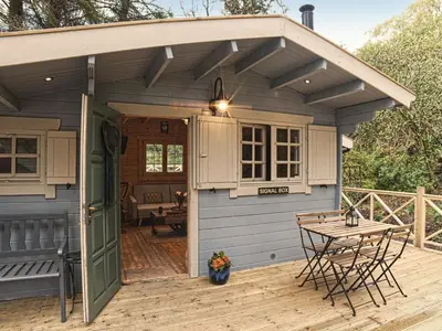 a small blue shed with a table on a deck at The Signal Box in Girvan