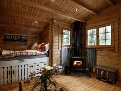 a log cabin bedroom with a bed and a fireplace at The Signal Box in Girvan