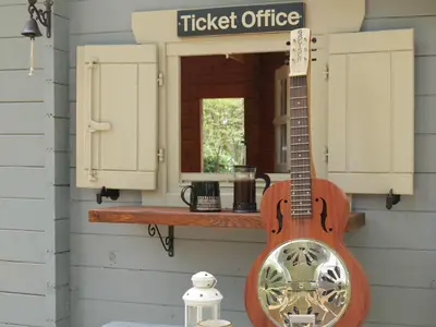 a guitar hanging on the wall of a ticket office at The Signal Box in Girvan