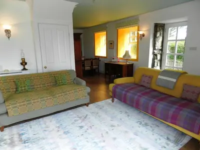 a living room with two couches and a rug at Castleside Croft in Kildonan
