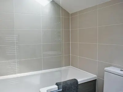 a bathroom with a bath tub and a toilet at 2 Northbank Cottages in Whiting Bay