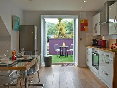 a kitchen with a table and a dining room at 2 Northbank Cottages in Whiting Bay