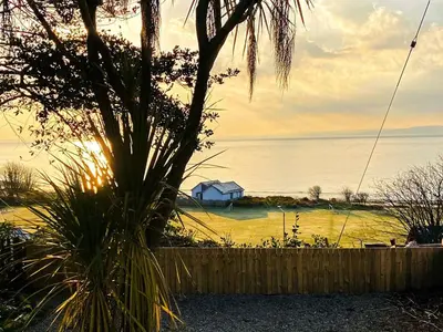 a house in the middle of the water with a fence at 2 Northbank Cottages in Whiting Bay