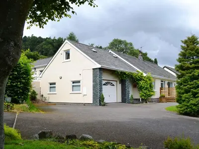 a white house with a garage at Oakvale - Oak Leaf in Braithwaite