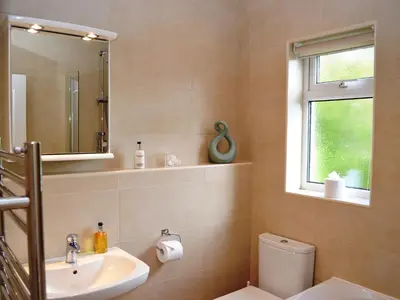 a bathroom with a sink and a toilet and a window at Oakvale - Acorn in Braithwaite