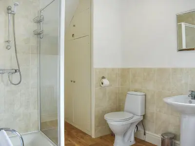 a bathroom with a toilet and a sink and a shower at Cumberland Place in Keswick